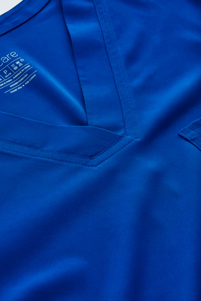A V-neck scrub top in a vibrant blue colour, featuring a pocket and a logo.