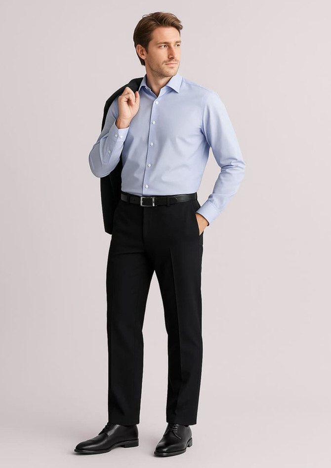 A man in a light blue shirt and black slacks stands confidently, holding a jacket over his shoulder. The slacks feature a logo.
