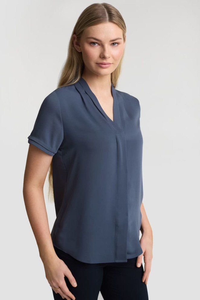 A women's button-up shirt in a navy blue colour with short sleeves and a v-neck design. It features a logo.