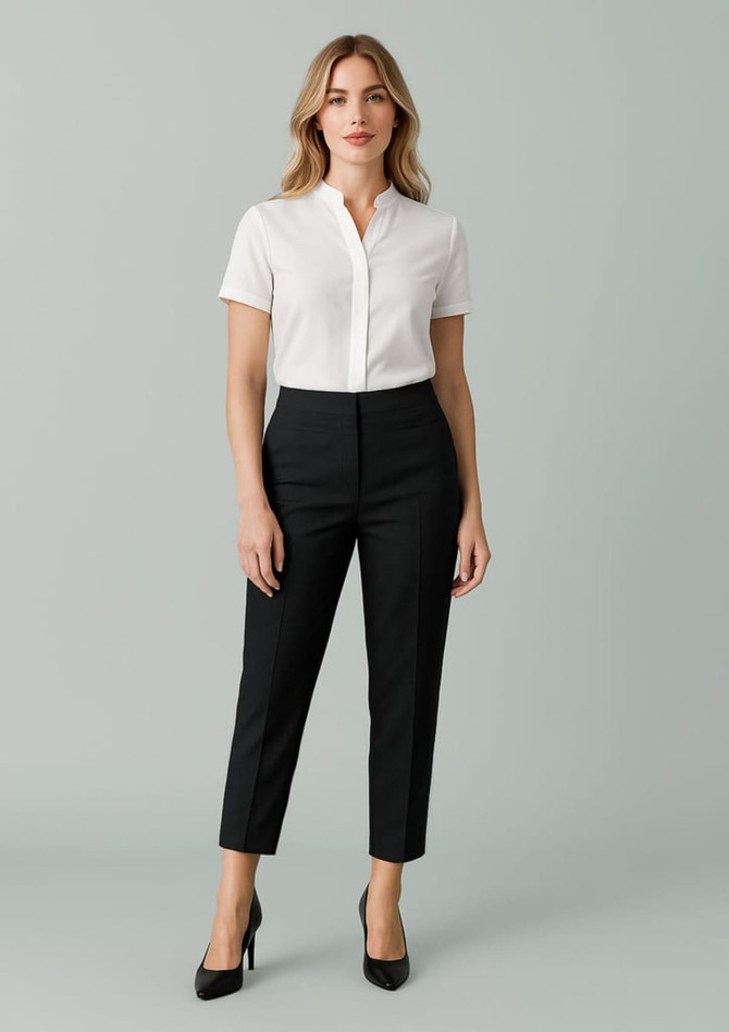 A pair of women's mid-waist slim leg pants in black, styled with a white shirt and featuring a logo.