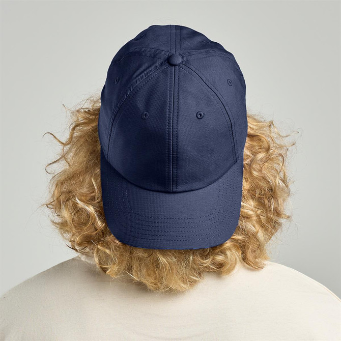 A navy cap with a rounded crown viewed from the back, featuring a button at the top and a branded logo.