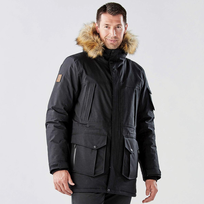 A men's black explorer parka with a fur-lined hood and multiple pockets, featuring a logo on the sleeve.