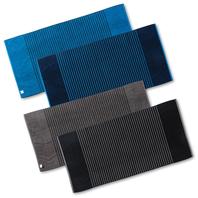 Reversible two-tone towels in blue, dark blue, grey, and charcoal, featuring striped patterns and a logo.