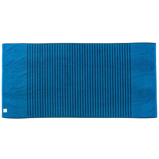 A reversible two-tone towel in deep blue with textured stripes, featuring a small logo on one corner.