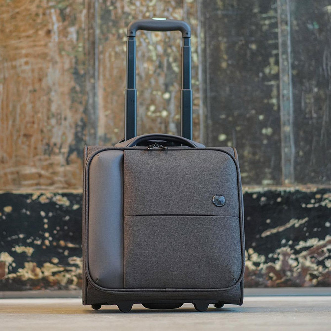 A wheeled bag in dark brown, featuring a retractable handle and a front pocket, with a logo on the side.