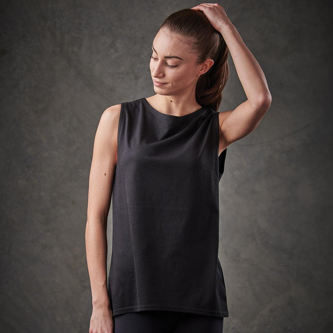 A woman wearing a black tank top with a sleek design, featuring an unobtrusive logo.
