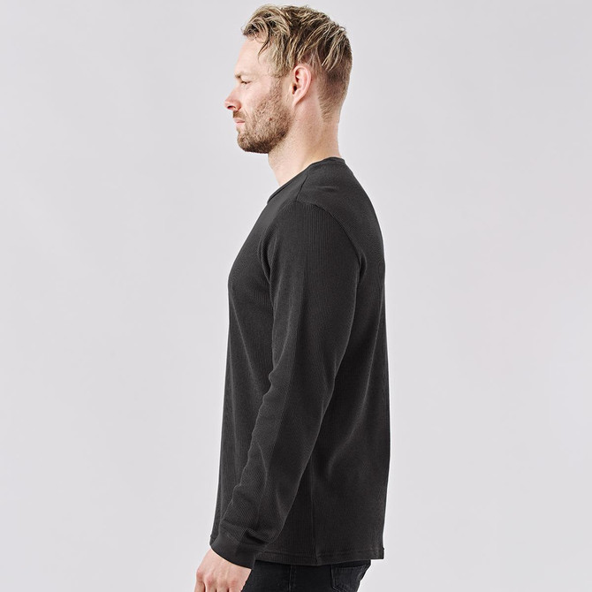 A men's crew neck shirt in dark grey, featuring long sleeves and a fitted silhouette. It has a logo on the front.