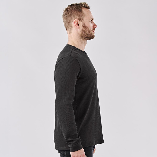 A black crew neck long-sleeve shirt displayed on a model from the side, showcasing its fit and style.