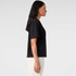 A black short-sleeve tee displayed on a model from the side, featuring a relaxed fit.
