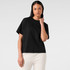 A black box tee featuring a relaxed fit and short sleeves, paired with light-coloured dress shorts.