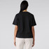 A black boxy tee featuring short sleeves and a simple cut, worn with light-coloured dress shorts.