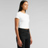 A white short-sleeve cropped T-shirt on a model, paired with black trousers. The shirt has a simple design and logo.