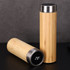 A drink bottle featuring a bamboo exterior and stainless steel accents, with a digital display showing temperature.
