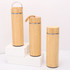 A drink bottle trio in natural bamboo finish, featuring metal accents and various styles, displayed on a white platform.
