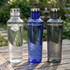 A drink bottle trio featuring translucent designs in clear, blue, and grey colours with stainless steel lids.