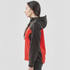 A women's softshell jacket featuring a black and red design with a hood and side zip pockets. It has a logo.
