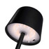A black mini rechargeable lamp featuring a cylindrical shade and a circular light base, with a charging port visible.