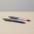 A metal pen set featuring a blue and a pink pen, both with a sleek design and branding on the barrel.