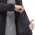 A black soft shell jacket with a zippered pocket, showcasing a hand reaching for a phone inside the jacket.