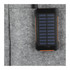 A black and orange solar power bank with a textured surface, placed in a grey felt pocket.