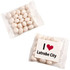 A clear bag containing chewy white mints, with an unbranded side and a logo featuring a heart and text.