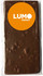 A chocolate bar wrapped in clear packaging, coated in milk chocolate, with a circular sticker on the front.