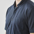 A navy short sleeve button-up shirt featuring a chest pocket and a logo.