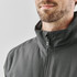 A grey thermal jacket featuring a high collar and zip closure, modelled by a man with a beard.