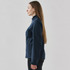 A softshell jacket in navy blue, featuring a zip pocket, shown from the side on a model with long hair.