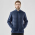 A man wearing a navy thermal softshell jacket with a quilted front, featuring a zip and side pockets.