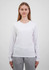 A woman wears a white long sleeve tee, paired with grey trousers. The tee features a simple design and has a logo.