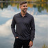 A men's charcoal grey 1/4 zip pullover in a scenic outdoor setting by a body of water.