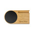 A bamboo cup warmer with a black circular heating area and a slot for a phone, featuring a logo.