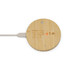 A round bamboo wireless charger with a white charging cable connected. It features a minimal design and has a logo.