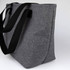 A grey lunch bag with black straps, featuring a simple design and an external logo.