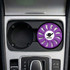A round lavender air freshener sits in a car cup holder, featuring a logo in the centre.