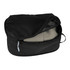 A black compression packing cube with a zippered opening, containing folded clothing inside.