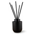 A black botanical reed diffuser with five black reeds, designed for fragrance dispersal.