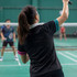 A women's active polo shirt in black with turquoise and pink accents, featuring a logo.