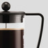A French press with a black lid and handle, featuring a glass body showcasing brewed coffee inside.