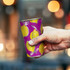 A drink cup featuring a vibrant purple design with yellow lemons and a silver rim, held in a hand.
