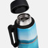 A drink bottle with a blue and scenic design, featuring a black handle and a stainless steel opening.