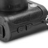 A compact black mini camera featuring textured detailing and control buttons on the side.