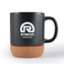A ceramic mug with a cork base, featuring a logo for "Robson Minerals." The mug is matte black with a sturdy handle.