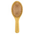 A bamboo hairbrush with a wooden handle and bristle pins, featuring a smooth oval design in natural tones.