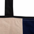 A zippered tote bag in beige and navy blue, featuring sturdy straps and stitched details.