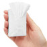 A hand holding a small, white packet of tissues with multiple tissues protruding from the top.