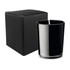 A black glass candle in a sleek holder, accompanied by a plain black box.
