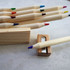 A set of wooden coloured pencils in various hues, with a sharpener alongside some of the pencils.
