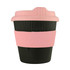 A reusable coffee cup in black with a pink silicone band and lid, featuring a ribbed design and branding.